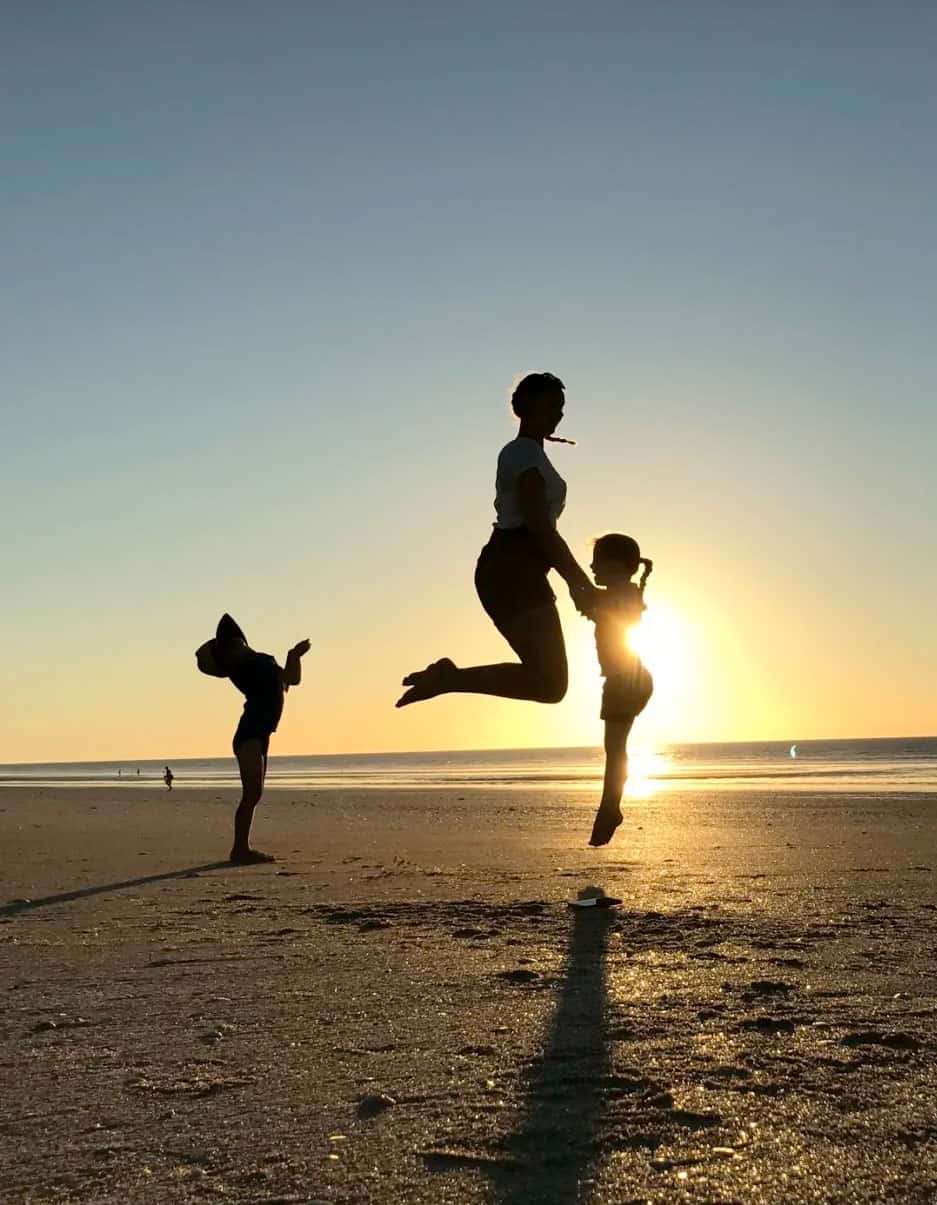 Au pair and children playing at the beach.